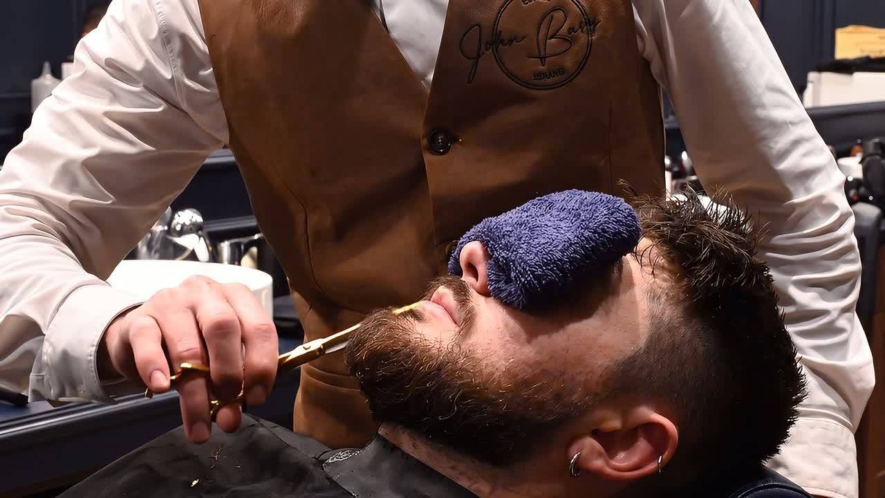 Un barbiere John Barber rade la barba di un cliente con il rasoio a mano libera